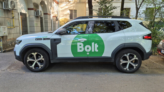 Side view of a white Dacia Duster SUV with Bolt ridesharing branding parked on a city street. Picture taken on June 16, 2026 in Bucharest, Romania.