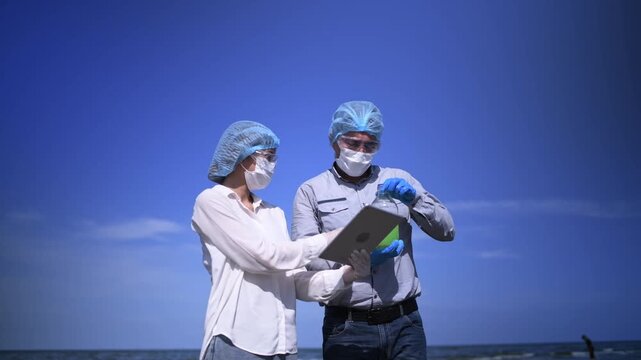 Scientist annalist wearing protective uniform, mask ,glove and under working water analysis effected from phytoplankton at sea analyst case in laboratory is environment pollution problem concept.