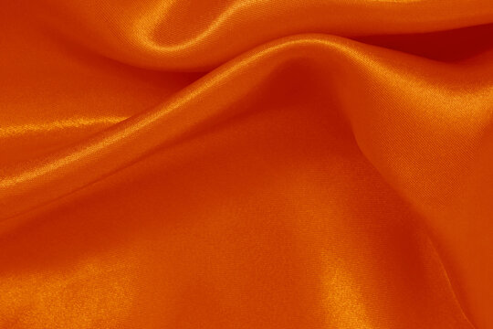 Orange fabric cloth texture for background and design art work, beautiful crumpled pattern of silk or linen.