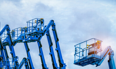 Articulated boom lift. Aerial platform lift. Telescopic boom lift against blue sky. Mobile construction crane for rent and sale. Maintenance and repair hydraulic boom lift service. Crane dealership. © Fahroni