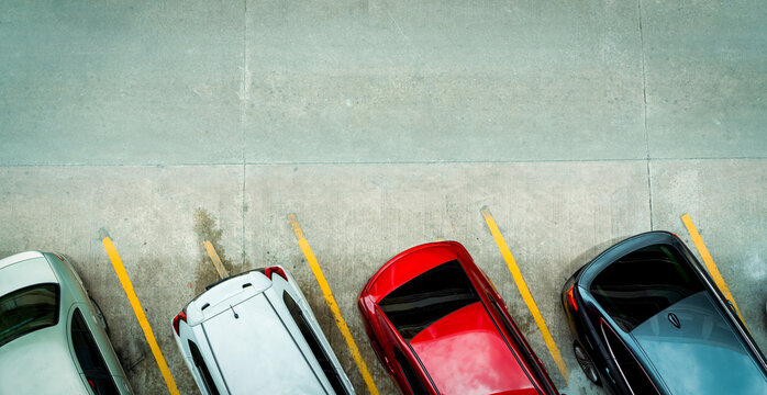 Top view of car parked at concrete car parking lot with yellow line of traffic sign on the street. Above view of car in a row at parking space. No available parking slot. Outside car parking area.