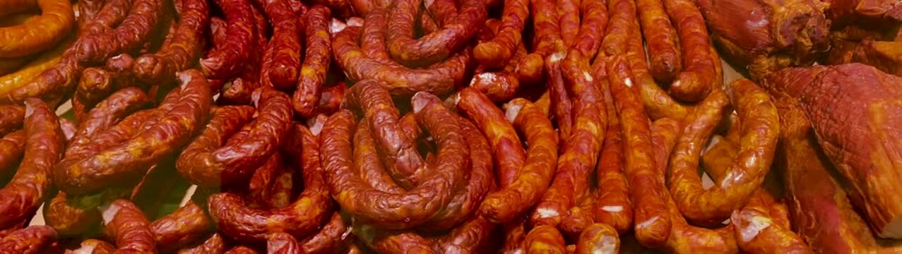Traditional meat products including various types of sausage displayed for sale at a deli counter or food market.