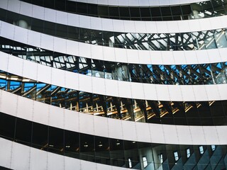 Architecture details Modern building Curve Glass window Reflection Metal tiles Abstract background © VTT Studio