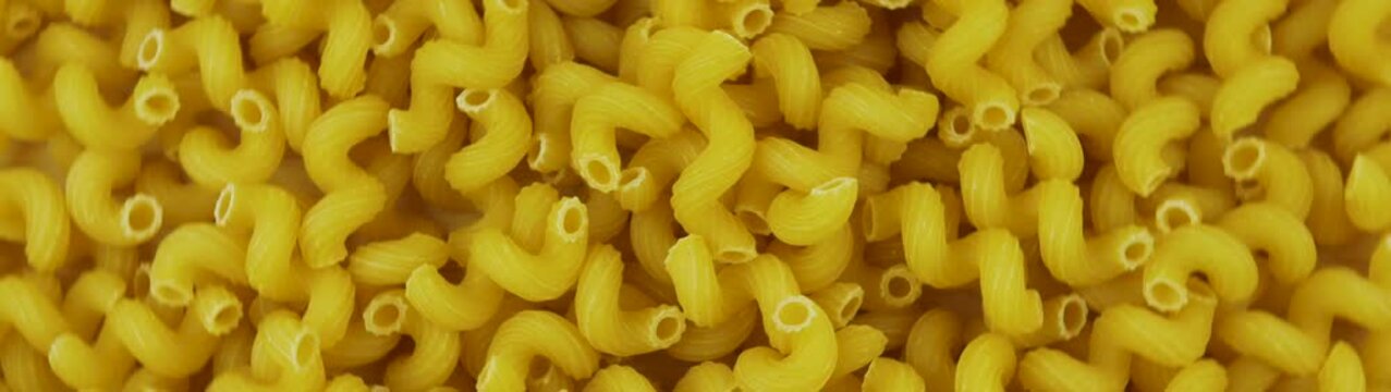 Cavatappi pasta creating a uniform full frame pattern Uncooked dry macaroni noodles ready for cooking.