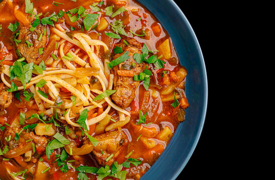 Lagman soup with beef, noodles, and vegetables in bowl