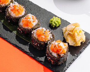 Fresh salmon maki sushi rolls on a slate board © AntAlexStudio