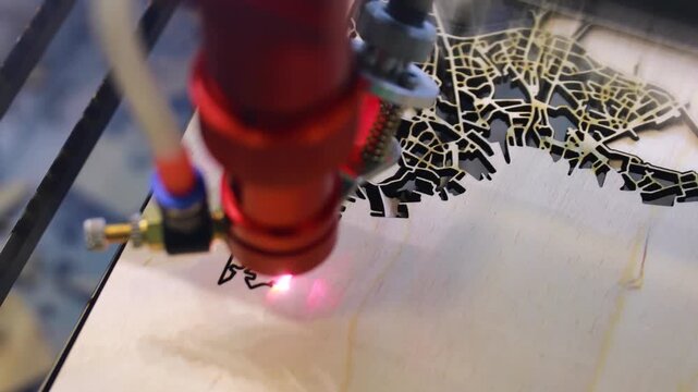Laser cutter engraves intricate city map design onto wooden surface with precision.