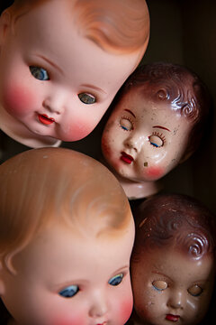 Unique collection of vintage porcelain doll heads in a box