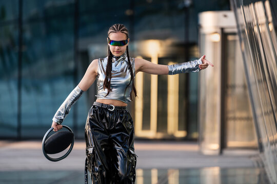 Stylish young woman in silver futuristic clothes