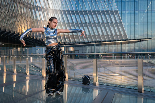 Stylish woman dancing in a futuristic urban setting