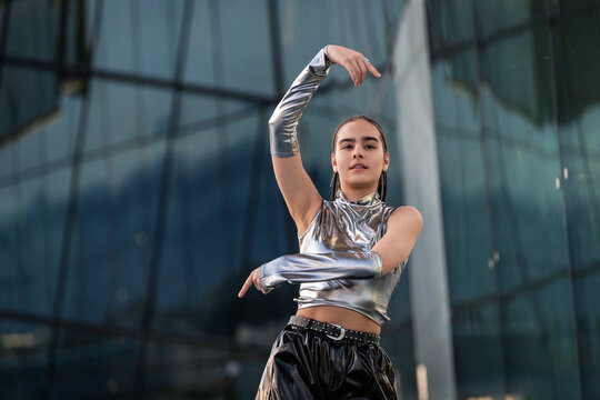 Confident young person dancing in futuristic outfit