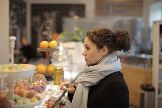 Woman in cafe choosing a sweet treat from display