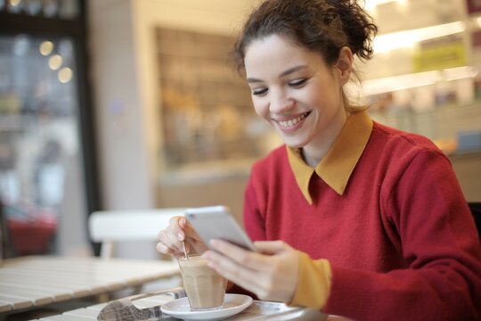 Young woman smiling while checking her smartphone