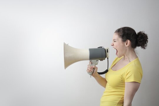 Angry woman shouting into a vintage megaphone