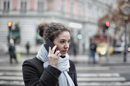 Woman on a phone call while crossing a city street