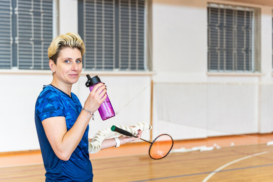 Woman badminton player takes a break on court