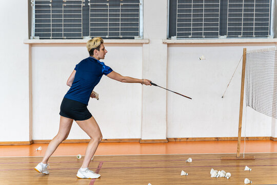 Female badminton player practicing her shot indoors