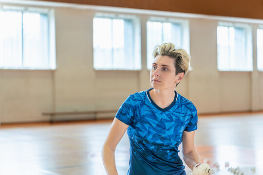 Focused female badminton player on an indoor court