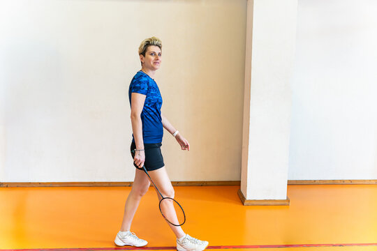 Woman with short hair walking on badminton court