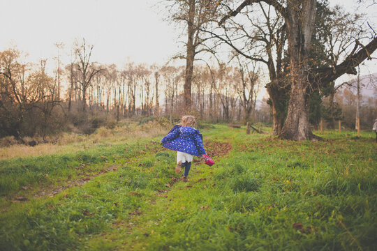 A young girl runs through a grassy filed