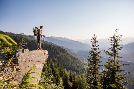 Male backpacker standing on a rocky mountain viewpoint