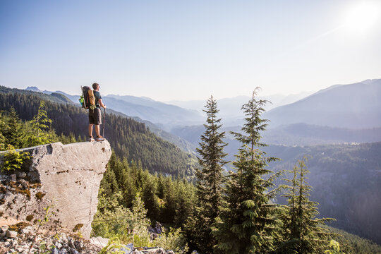 Hiker looks out over a vast mountain valley