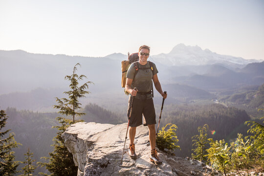 Smiling hiker pauses on a scenic mountain overlook