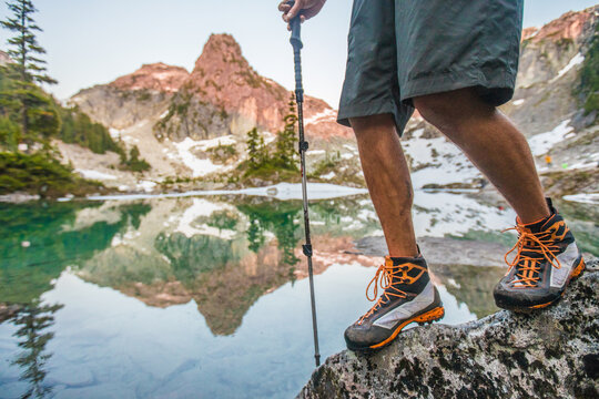 Man hiking on a rock by an alpine lake