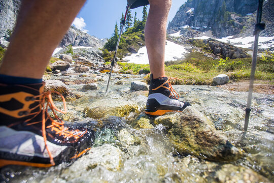 Low angle shot of a hiker crossing a mountain stream