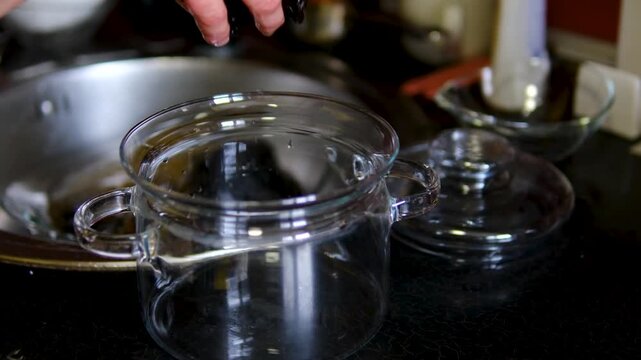 Washing dried prunes in glass bowl before cooking homemade recipe preparation process close up