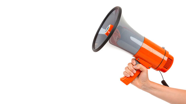 Human hand holding a bright orange megaphone loudspeaker isolated on transparent background cut out