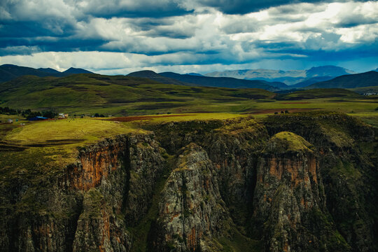 View of steep rocky cliffs and deep canyons of the Maletsunyane River gorge under a dramatic cloudy sky in the highlands Maseru, Lesotho.