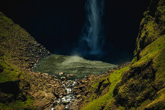 View of Maletsunyane Falls plunging into a deep pool surrounded by steep rocky cliffs and green slopes Maseru, Lesotho.