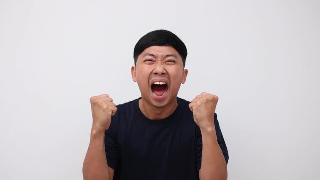 Man sreaming and feeling very angry at face show fists up,Asian man shout very loudly white background slow motion