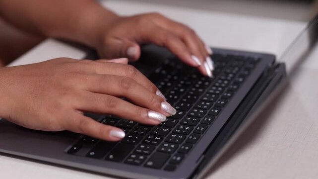 Close up woman hand typing keyboard laptop on table slow motion