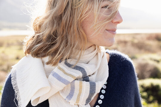 young stylish woman wearing scarf overlooking Klein Mountains and Lagoon, Stanford, South Africa