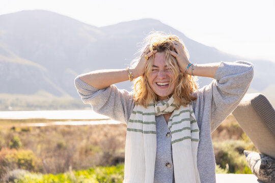 young stylish woman wearing scarf overlooking Klein Mountains and Lagoon, Stanford, South Africa