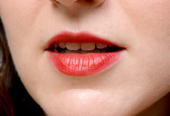 Naklejka premium Nahaufnahme eines lächelnden Mundes mit rotem Lippenstift. Ausdrucksstarkes Beauty-Motiv für Kosmetik, Zahngesundheit, Lippenpflege, Schönheit und Selbstbewusstsein.