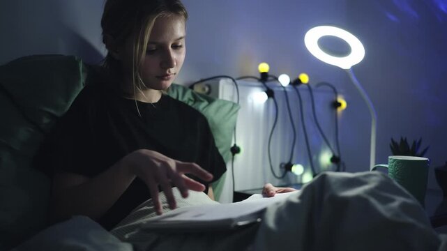 Cute Little Girl Reading A Book As Homework In Bed Before Sleep In A Cozy Kids Room