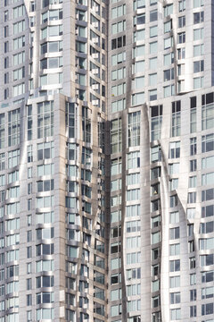 Architectural detail of a wavy metallic skyscraper facade soaring upwards, representing modern urban development and travel exploration in the heart of New York City, Lower Manhattan.
