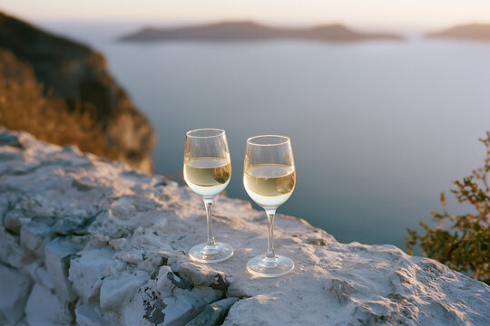 Two glasses of champagne are sitting on a rock by the sea. Vacation, honeymoon. 