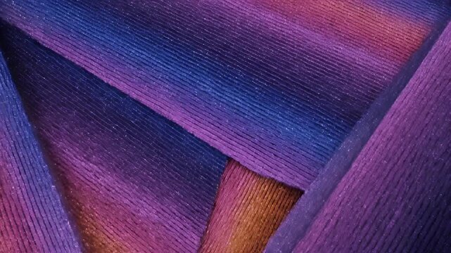 Abstract macro view of iridescent, textured strands in shades of blue, purple, and orange