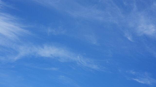 A blue sky timelapse video footage featuring delicate cirrus clouds drifting across the atmosphere, illustrating changing weather patterns, climate variability, and the impact of global warming. 4k.
