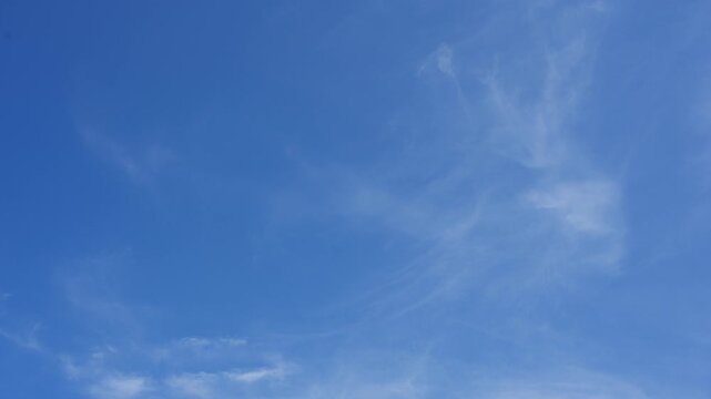 A blue sky timelapse video featuring delicate cirrus clouds drifting across a clear atmosphere, symbolizing climate awareness, weather forecasting, environmental education, renewable energy promotion,