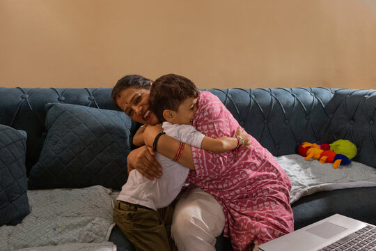 Mother and son sharing a warm hug on the couch