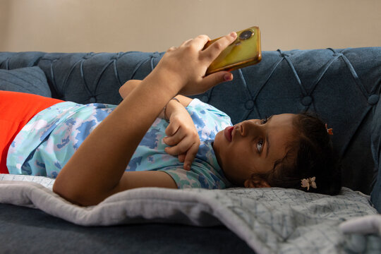 girl relaxing on sofa and scrolling on her smart phone