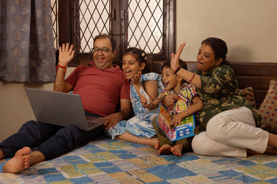 a happy moment shared by family over watching a video on laptop