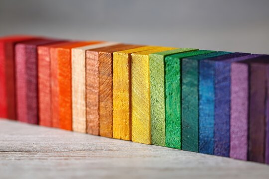 Rainbow gradient of wooden blocks arranged in a spectrum for vibrant background use
