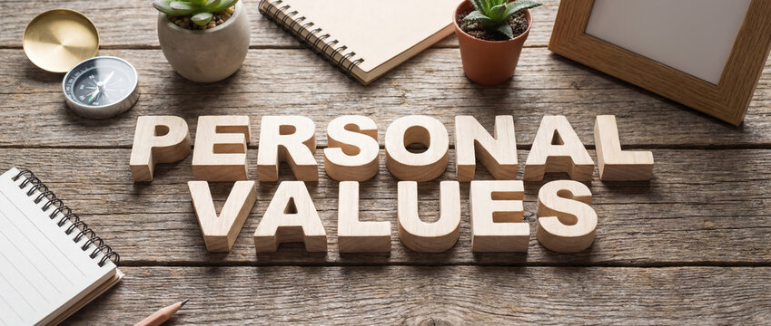 Personal values text made from wooden blocks on a vintage wooden table with a compass and notebook