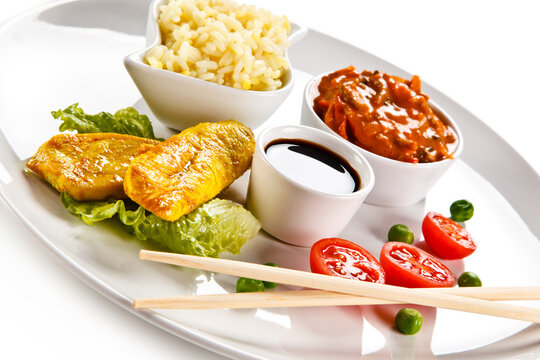 Fried chicken nuggets, white rice and vegetables on white background
